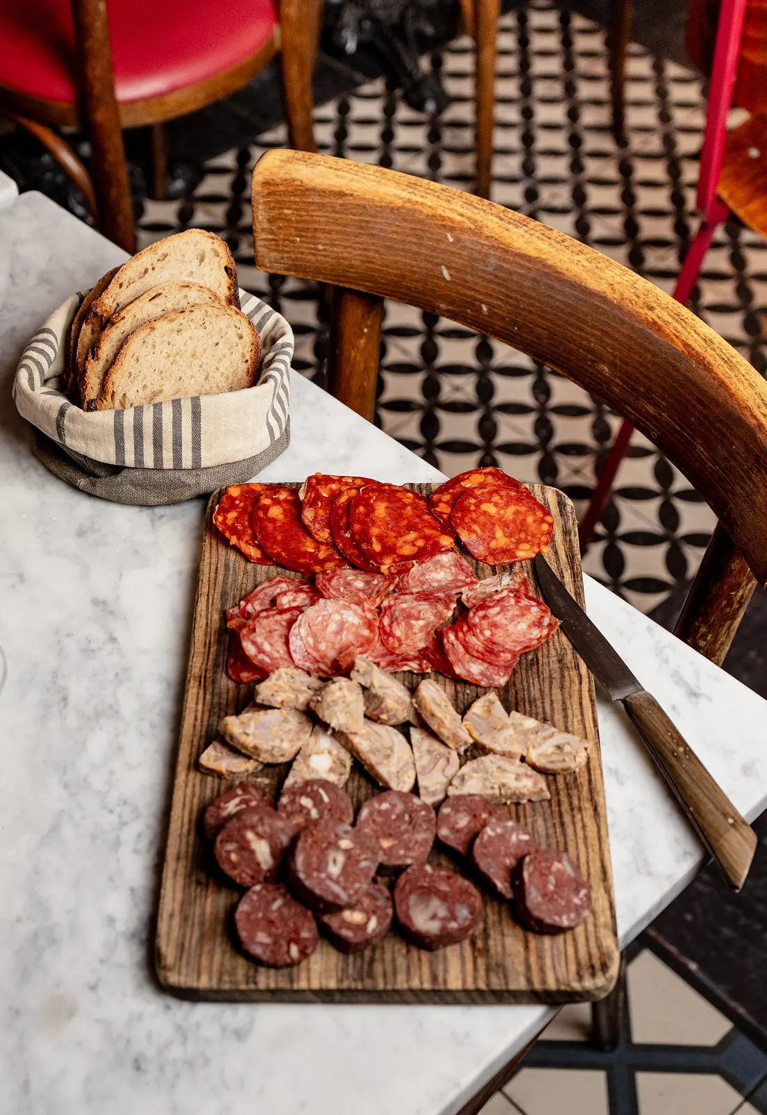 Planche de charcuterie et pain sur une table en marbre