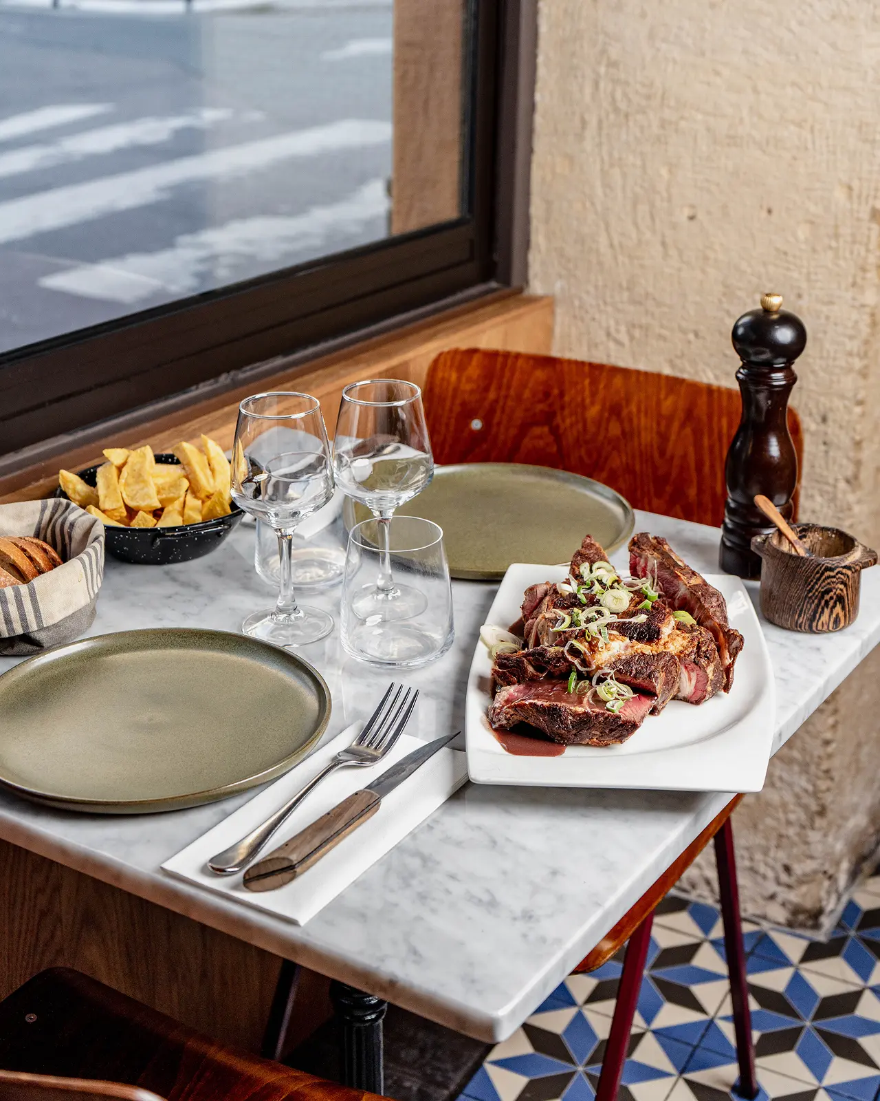 Table en marbre près de la fenêtre avec viande et frites